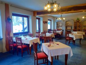 ein Esszimmer mit Tischen und Stühlen mit weißen Tischdecken in der Unterkunft Hotel Sciatori in Sestriere
