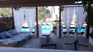a patio with white curtains and a pool at Hotel Mediterraneo in Ios Chora