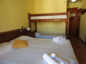 two bunk beds in a room with towels on them at Hotel Sciatori in Sestriere