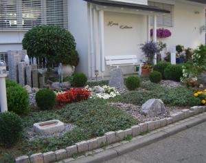 um jardim com flores e um banco em frente a um edifício em Haus Ketterer em Bad Dürrheim