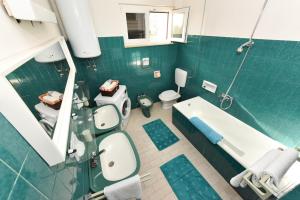 a bathroom with a tub and a toilet and a sink at Apartments Markulin 3562 in Preko