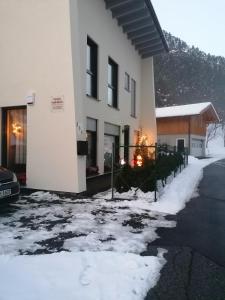 a white building with snow on the side of it at Pension kraft-weiler in Pfunds