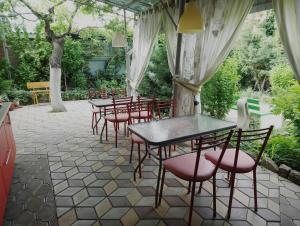 エイスクにあるGuest House on Kropotkinaのパティオ(テーブル、赤い椅子、テーブル、椅子付)