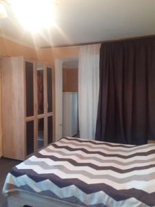 um quarto com uma cama com um cobertor listrado em Агрба 19/1 Квартира em Pitsunda