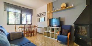 貝納薩的住宿－XALET de MUNTANYA，客厅配有蓝色的沙发和电视