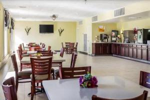 a restaurant with tables and chairs and a kitchen at Baymont by Wyndham Walterboro in Walterboro