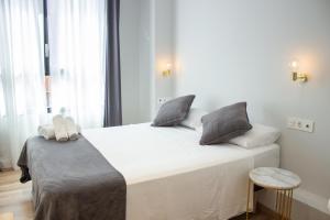 a hotel room with a white bed and white comforter at Pensión B4R in Bilbao