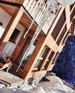 a house with wooden walls and windows on it at Lüch dl Jëinder in San Martino in Badia