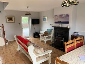 a living room with a couch and a fireplace at Cozy Coastal Cottage in Ballinskelligs, Kerry in Cahersiveen