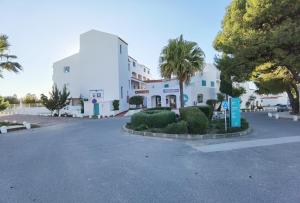 un grande edificio bianco con alberi e una strada di Prainha Loft Apartment ad Alvor