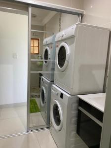 a laundry room with two washer and dryer at Peacock Cottage, 95 Eden Wilds in Port Edward