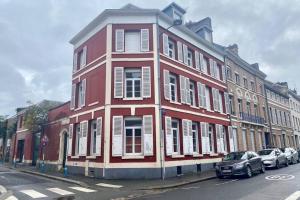 een rood gebouw met auto's ervoor geparkeerd bij Charmant T2 Hyper-centre, Netflix, Gare in Amiens