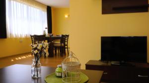a living room with a table with a vase of flowers at Вила Делфин - Villa Delfin in Bŭlgarevo