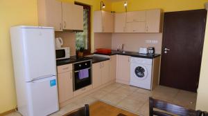 a kitchen with a white refrigerator and a dishwasher at Вила Делфин - Villa Delfin in Bŭlgarevo