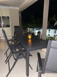 a black table and chairs with a candle on a balcony at Peacock Cottage, 95 Eden Wilds in Port Edward