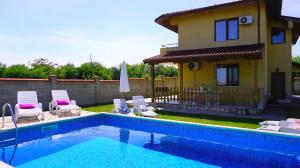 a house with a swimming pool in front of a house at Вила Делфин - Villa Delfin in Bŭlgarevo