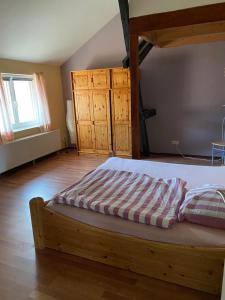 ein Schlafzimmer mit einem großen Bett und Holzboden in der Unterkunft Hof Beuck in Travenhorst
