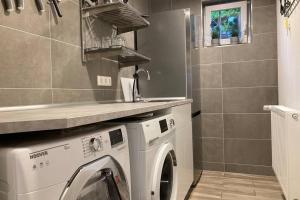 een wasruimte met een wasmachine en een wastafel bij Modernes Apartment Nr3 nahe Reeperbahn bis 8 Personen in Hamburg