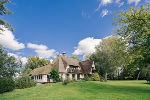 una casa vieja en un campo verde con árboles en "Reetland" - Haus Hartwig, en Tating