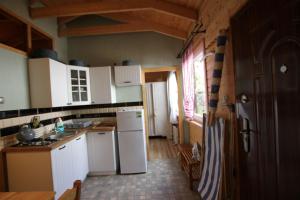 kuchnia z białymi urządzeniami i drewnianym sufitem w obiekcie Fitness - domek z ogródkiem w Stegnie