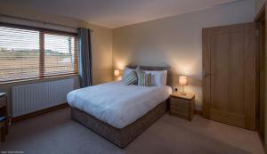 Un dormitorio con una cama grande y una ventana en Enniskillen Watersedge Apartments, en Enniskillen