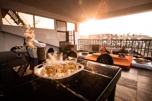 Assagao的住宿－Thor Villa, 5BHK-Private Pool-Cook-Caretaker，阳台配有带玻璃杯的桌子的房间