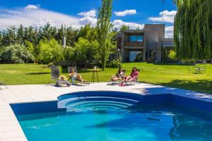 eine Gruppe von Menschen, die um einen Pool herum sitzen in der Unterkunft Casa de Huéspedes La Azul in Los Árboles