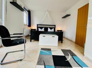 ein Schlafzimmer mit einem Bett, einem Stuhl und einem Teppich in der Unterkunft Dünenresidenz Karlshagen - Ferienwohnung Ginsterweg in Ostseebad Karlshagen