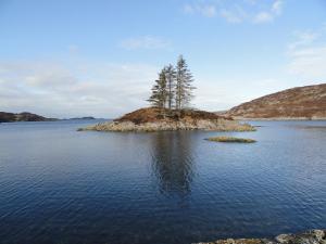 a small island in the middle of a body of water at Lochinver Holiday Lodges & Cottages in Lochinver