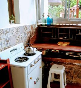 a kitchen with a stove with a tea kettle on it at Casita de Piedra B&B in Villa del Dique