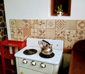 y cocina con hervidor de agua y fogones. en Casita de Piedra B&B en Villa del Dique
