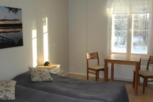 a bedroom with a bed and a desk and a table at Labbnäs Semesterhem, Radhuset in Kimitoön