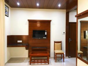 a room with a tv and a table and a chair at THE GRAND CORAL in Bengaluru