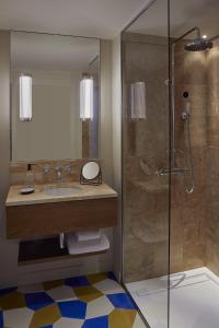 a bathroom with a sink and a shower at Hôtel du Sentier in Paris