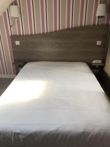 Un dormitorio con una cama blanca con dos luces. en Restaurant Hotel Logis Chez Sophie, en Briouze