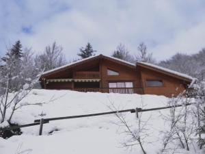 una casa en la nieve delante en Chalet le Bruleux, en La Bresse