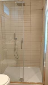 ducha con puerta de cristal y aseo en Prato Smeraldo Apartment, en Roma