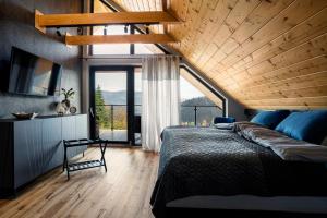 a bedroom with a large bed and a large window at Międzybrodzie Bialskie Apartamenty Nowy Świat in Międzybrodzie Bialskie