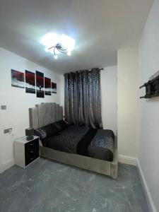 a bedroom with a large bed with a window at 3 Bedroom Whalley Aparthotel in Burnley