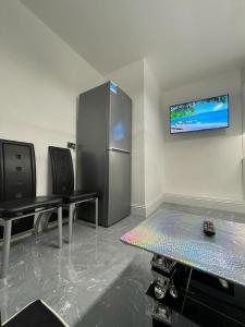 a kitchen with two tables and a refrigerator at 3 Bedroom Whalley Aparthotel in Burnley