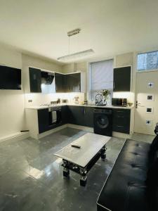 a large kitchen with a table in the middle of it at 3 Bedroom Whalley Aparthotel in Burnley