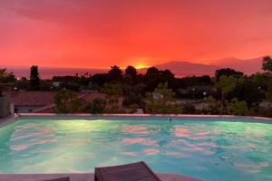 uma piscina com um pôr-do-sol ao fundo em Villa individuelle avec piscine privée chauffée proche commerces et plage em Porticcio
