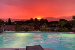 una piscina con puesta de sol en el fondo en Villa individuelle avec piscine privée chauffée proche commerces et plage en Porticcio