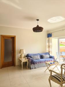 - un salon avec un canapé bleu et une table dans l'établissement Pé na Praia da Foz, à Foz do Arelho