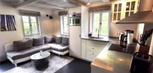 a kitchen and a living room with a couch at Urlaub im 200 Jahre alten Fachwerkhaus in Lichtenhain