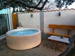 a large round bath tub sitting next to a bench at Manora guest pool house Sucuraj in Sućuraj