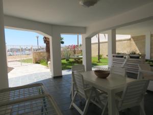 una mesa y sillas en un patio con vistas al océano en Salentoguests villetta sulla spiaggia, en Porto Cesareo