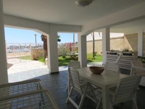 a table and chairs on a patio with a view of the ocean at Salentoguests villetta sulla spiaggia in Porto Cesareo