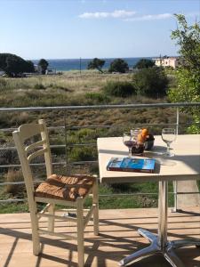 a table and chair on a deck with a view of the ocean at Blue Sky in Frangokastello