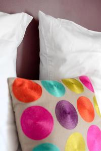 a bed with a pillow with polka dots on it at D'un jour à l'autre in Banassac